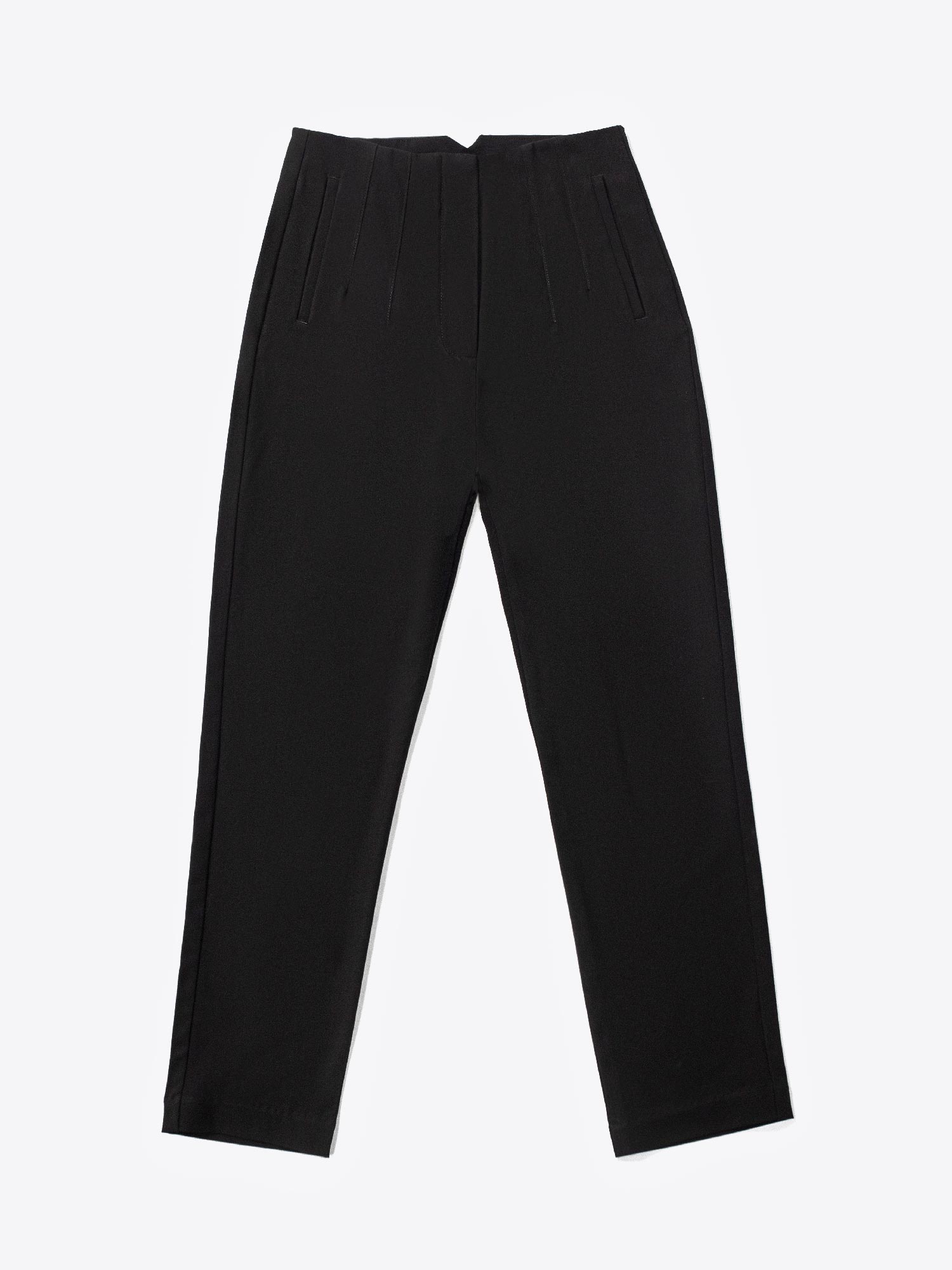 A close-up of a woman's hand placing into a front pocket of black high-waisted fitted pants.