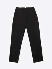A close-up of a woman's hand placing into a front pocket of black high-waisted fitted pants.