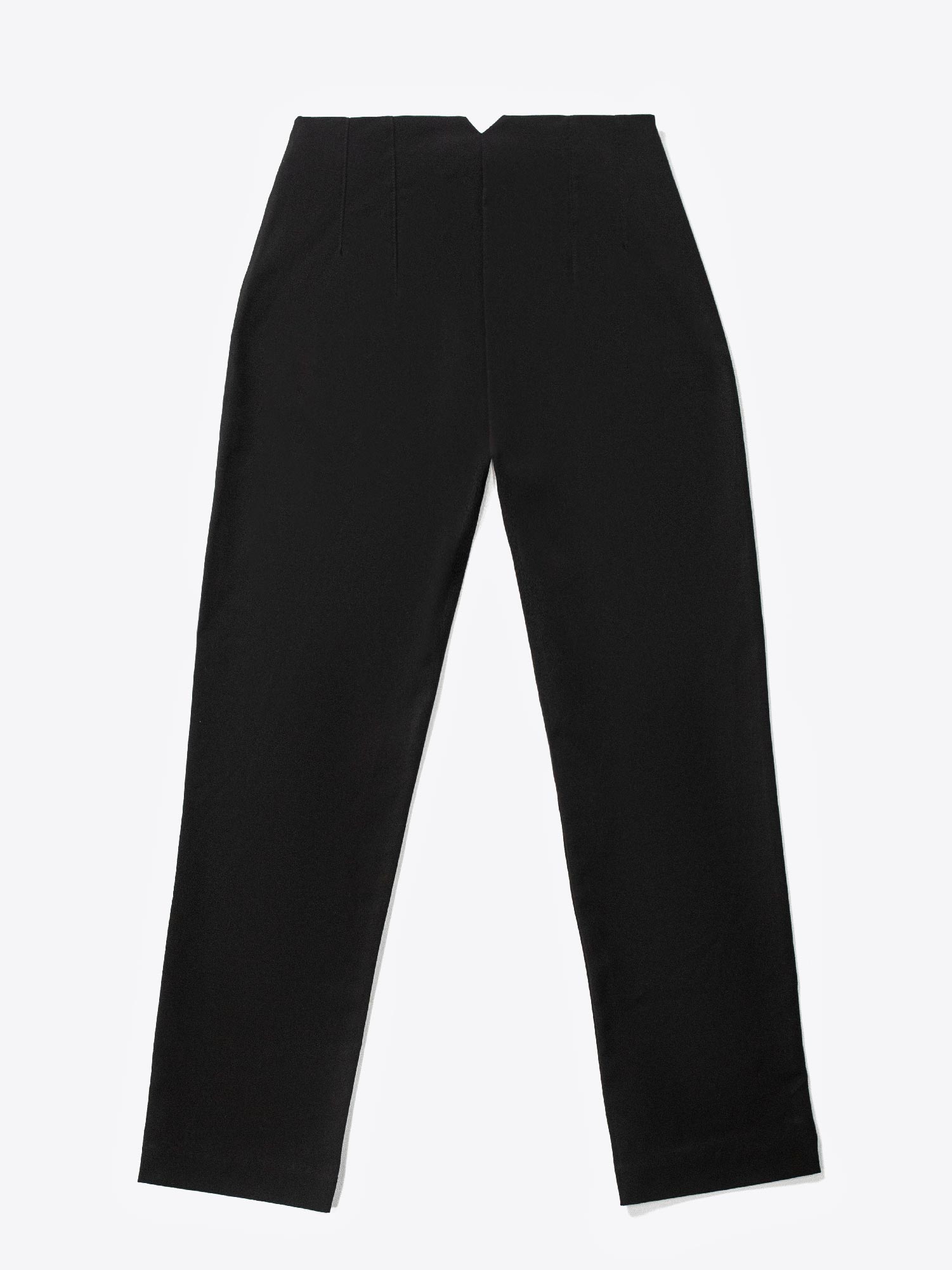 A close-up of a woman's hand placing into a front pocket of black high-waisted fitted pants.