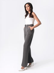 A woman in a white top and dark grey flared pants with front slits, fitted waist belt, and cross pockets.