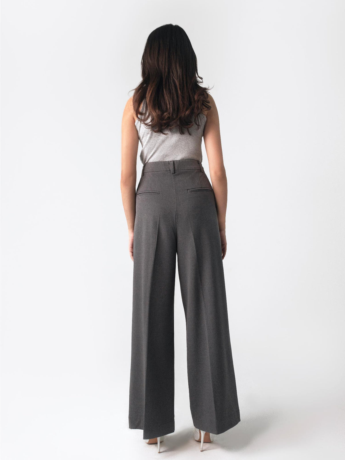 Low-rise black wide leg pants with a fitted belt, pleats, and multiple pockets, designed for a formal and smart look.