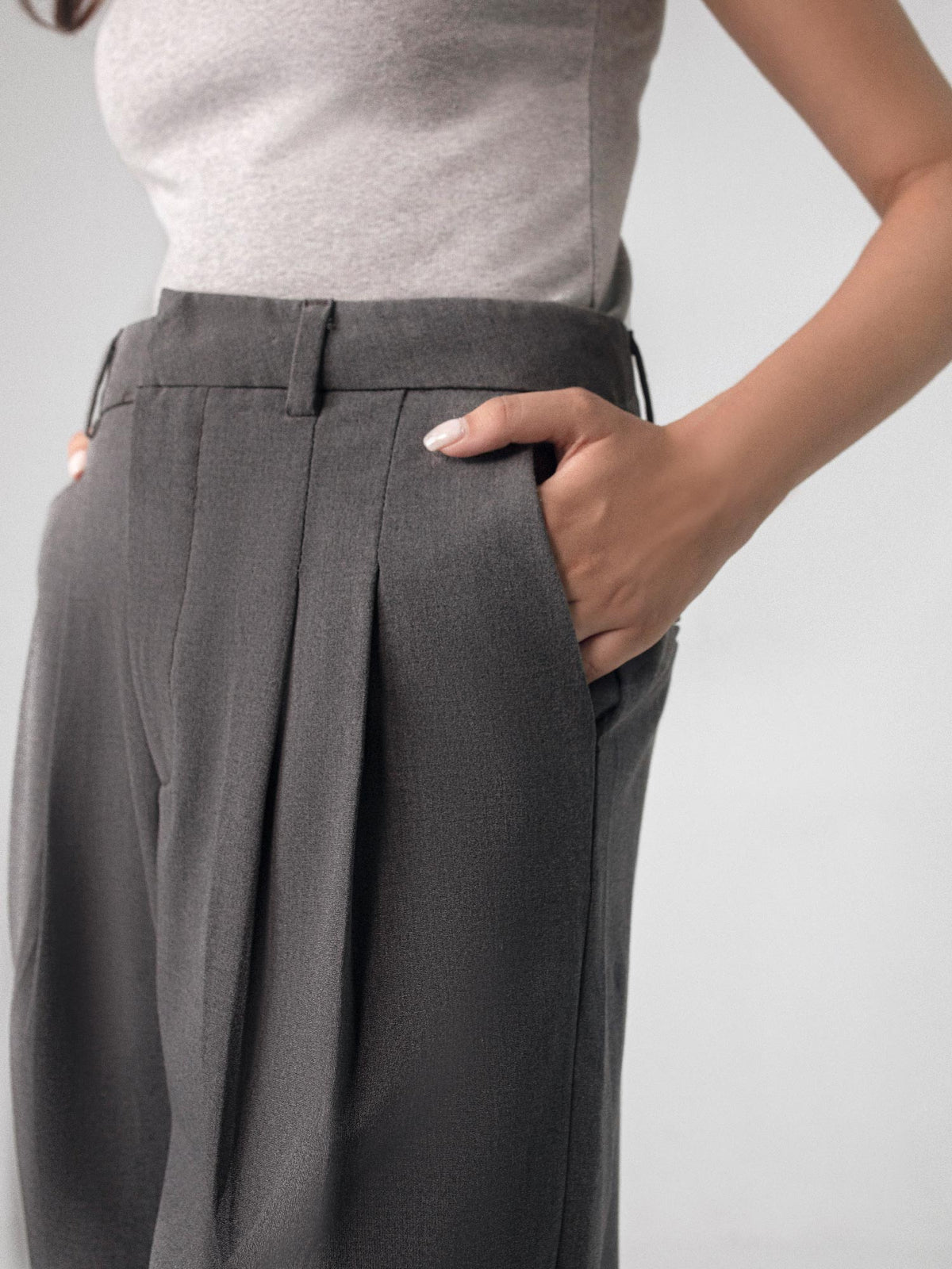 Low-rise black wide leg pants with a fitted belt, pleats, and multiple pockets, designed for a formal and smart look.