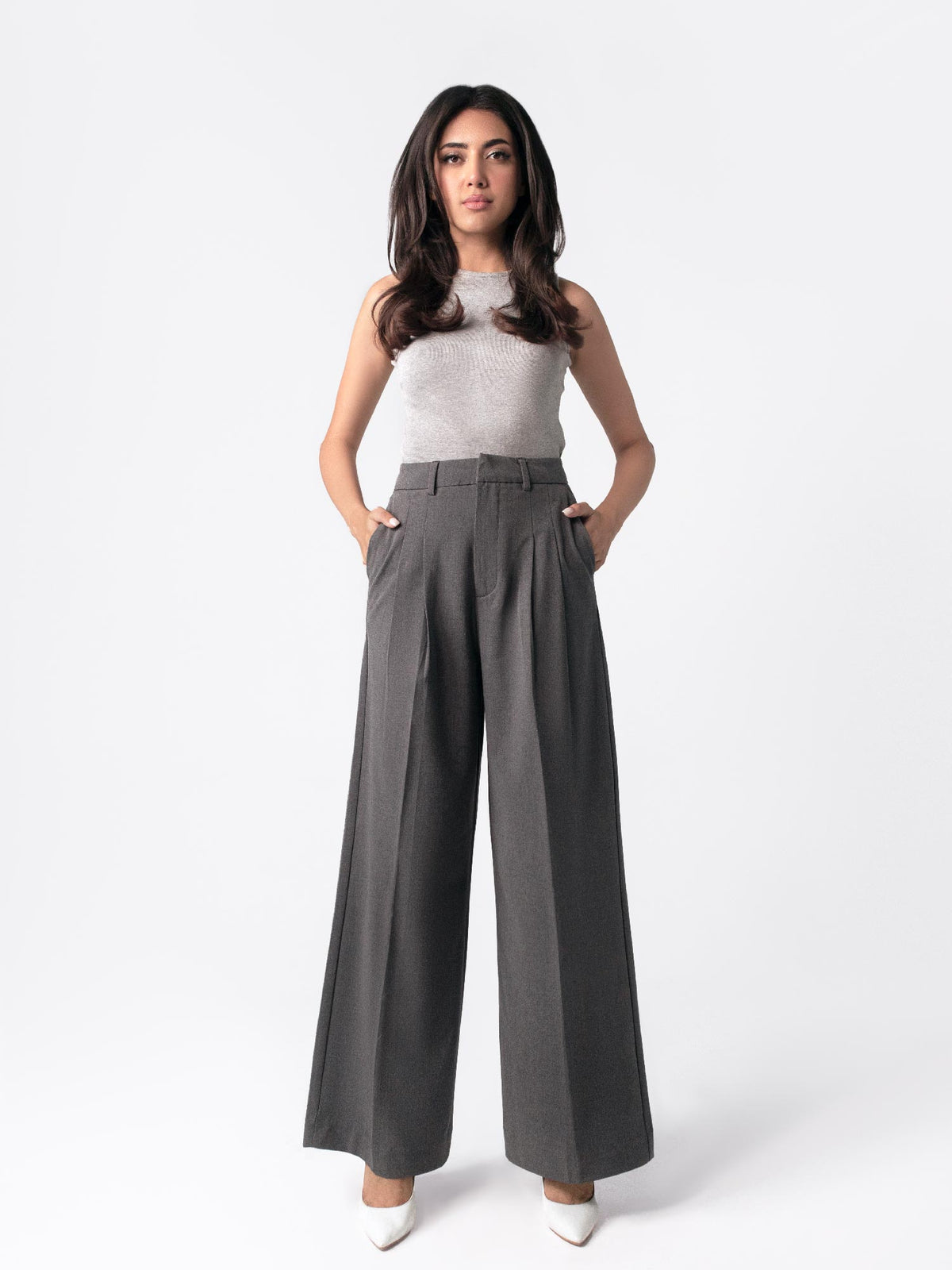 Low-rise black wide leg pants with a fitted belt, pleats, and multiple pockets, designed for a formal and smart look.
