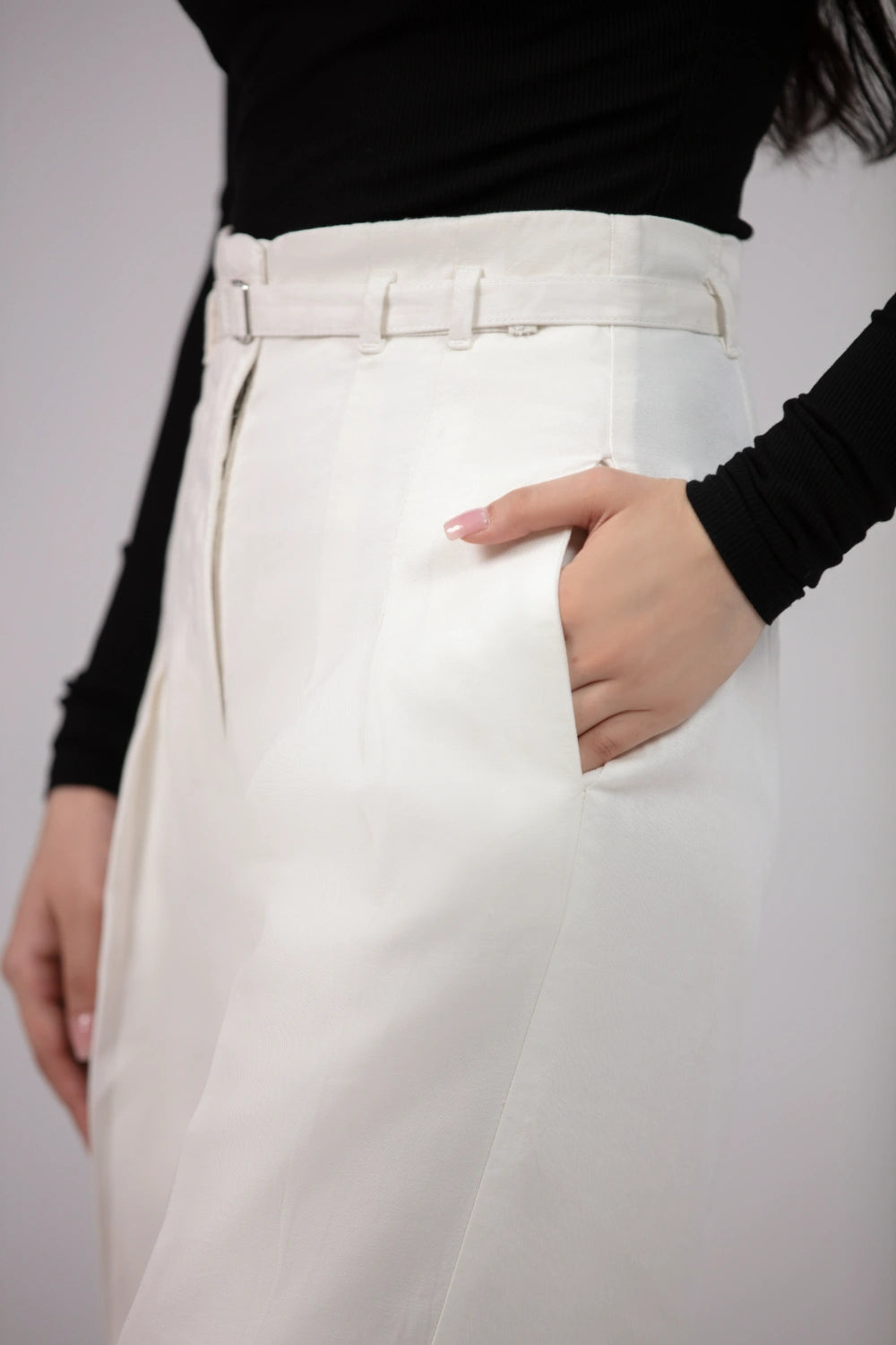 Person wearing white pants with a plain background