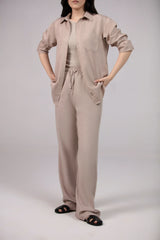 Person wearing a beige jumpsuit on a plain background