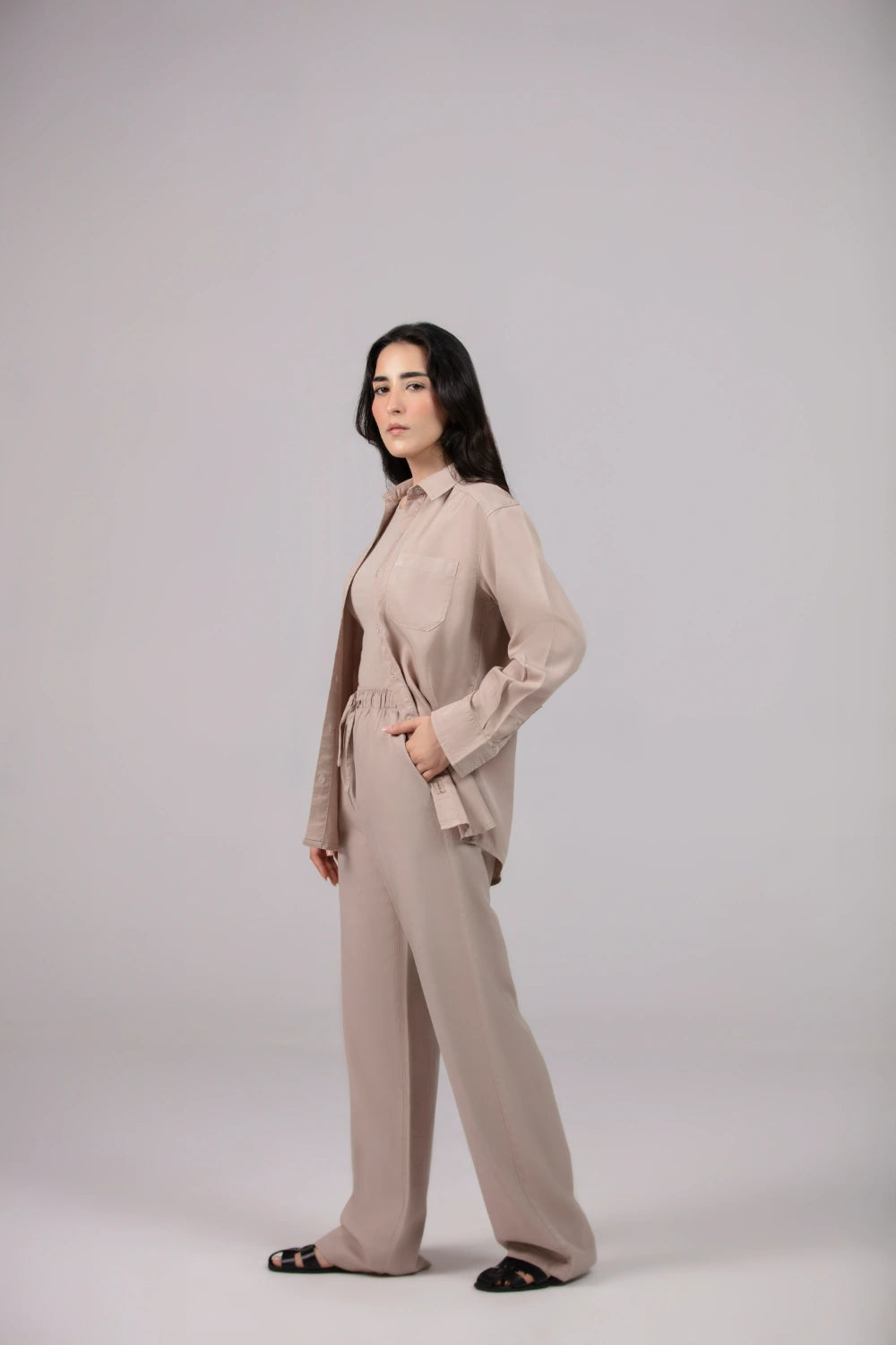 Woman wearing a beige outfit on a plain background