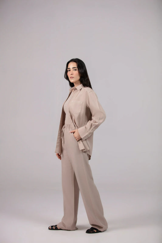 Woman wearing a beige outfit on a plain background