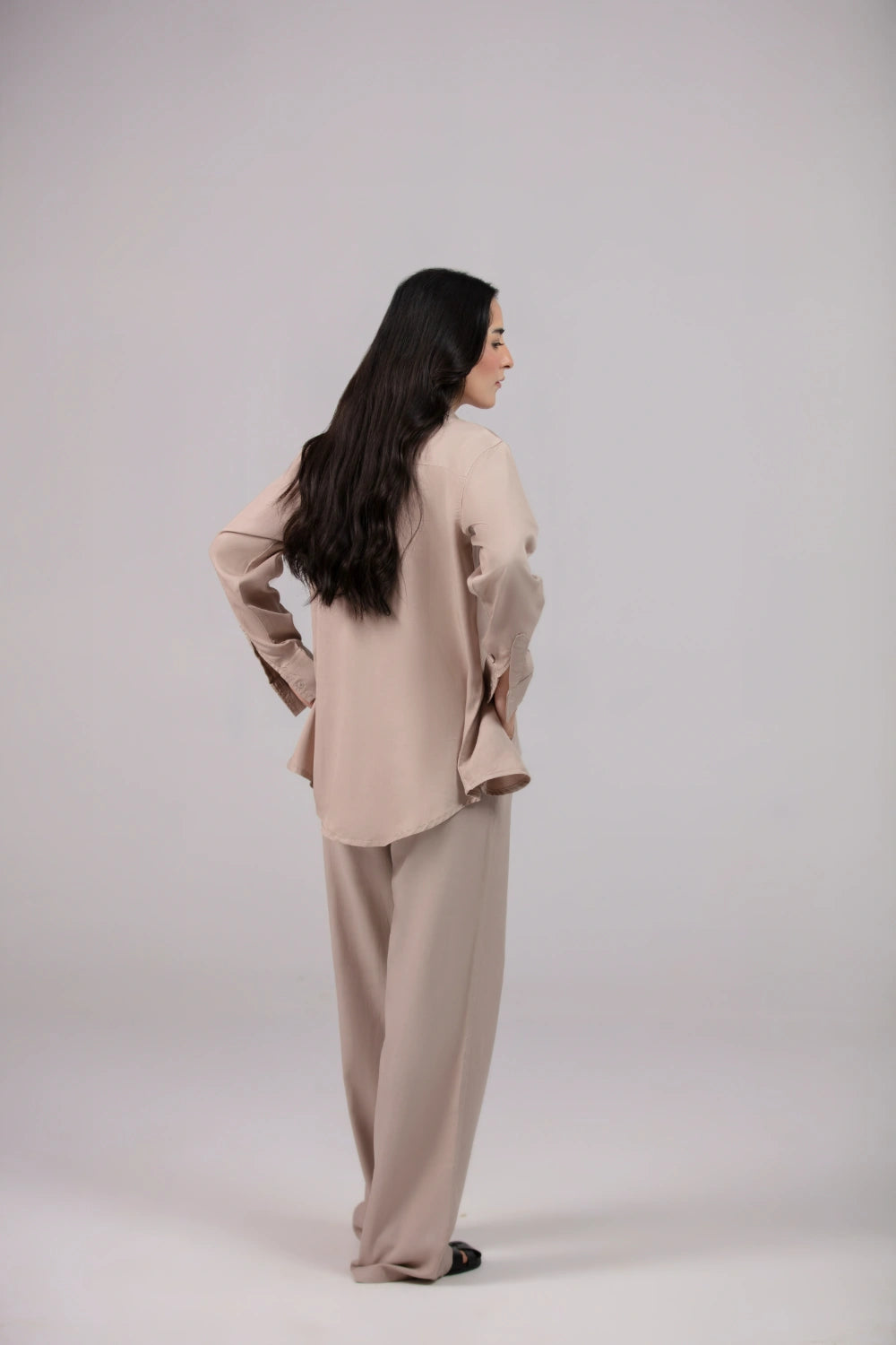 Woman wearing a beige outfit on a plain background