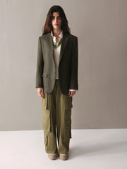 A woman wearing olive green cargo pants paired with a white sweater, presenting a relaxed and fashionable outfit.