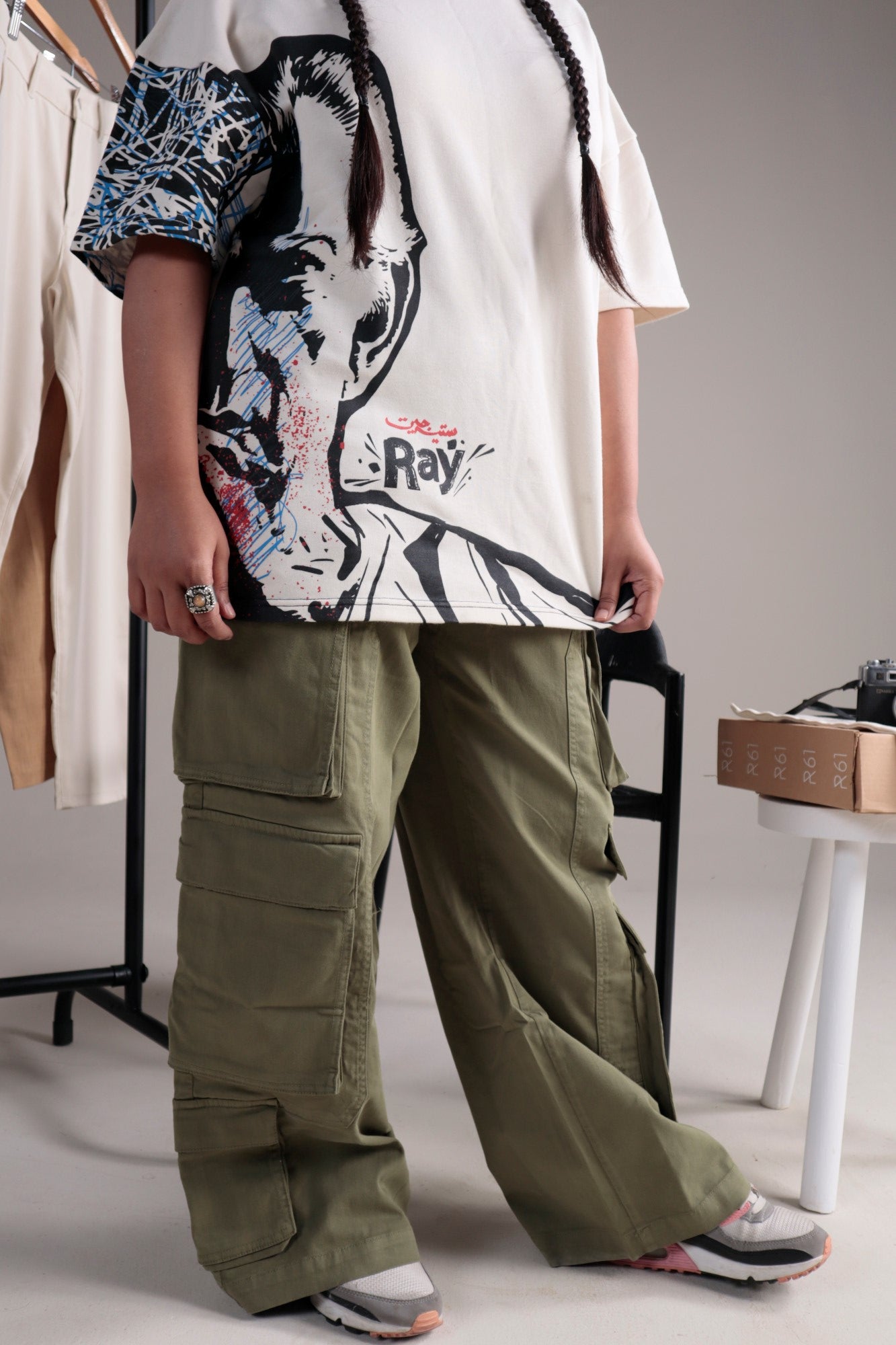 A woman wearing olive green cargo pants paired with a white sweater, presenting a relaxed and fashionable outfit.