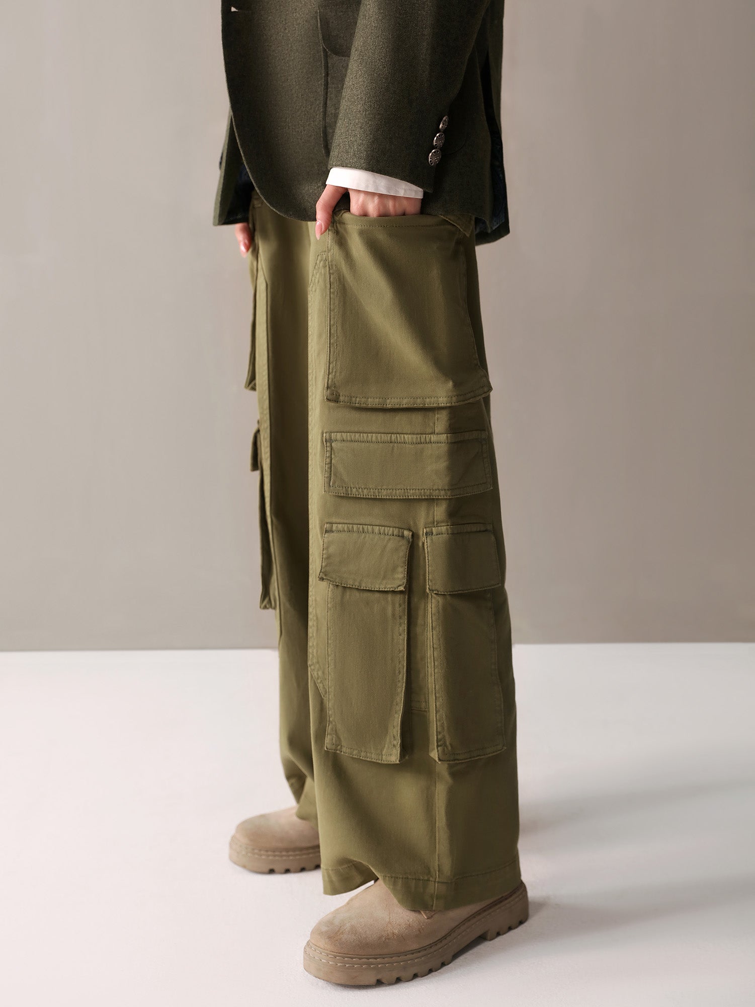 A woman in olive green cargo pants and a white sweater, embodying a chic and comfortable casual style.