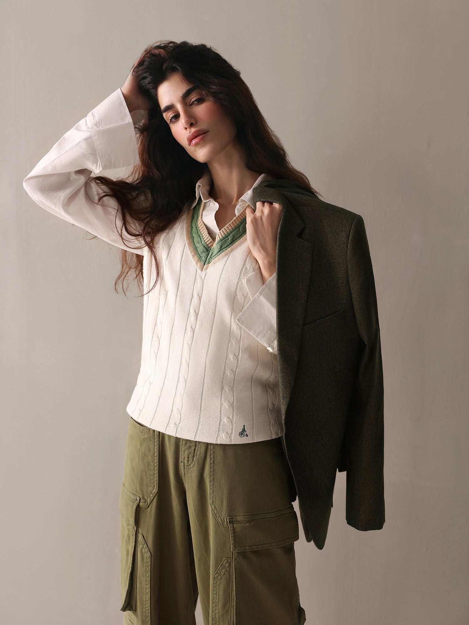 A woman wearing olive green cargo pants paired with a white sweater, presenting a relaxed and fashionable outfit.