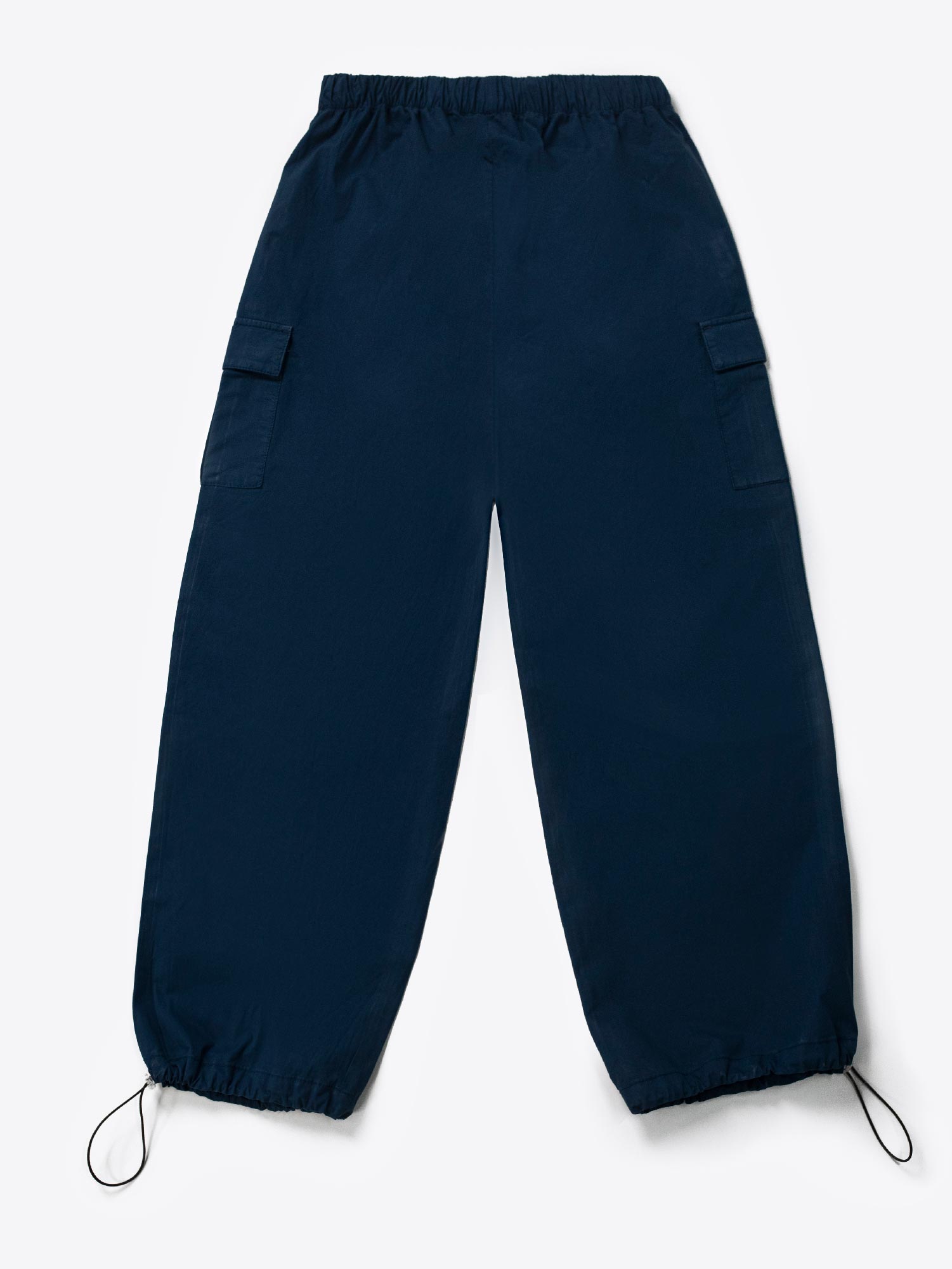 A woman standing and facing to the side, wearing navy blue wide leg cargo pants with an elasticated waistband and drawcord details.