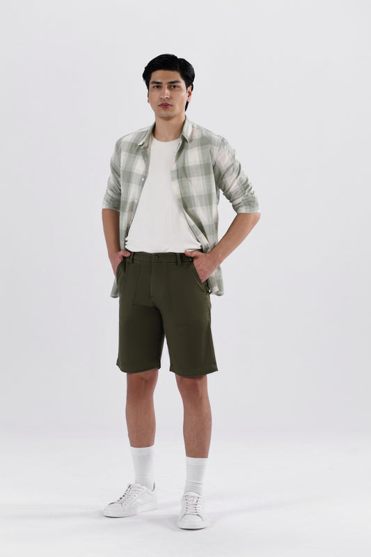 A pair of olive green safari shorts for men with a non-functional belt strap, classic patch pockets, and a zip fly opening.