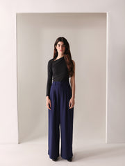 A close-up of a woman's navy wide-leg pants with double pleats, showing the fabric and design details.