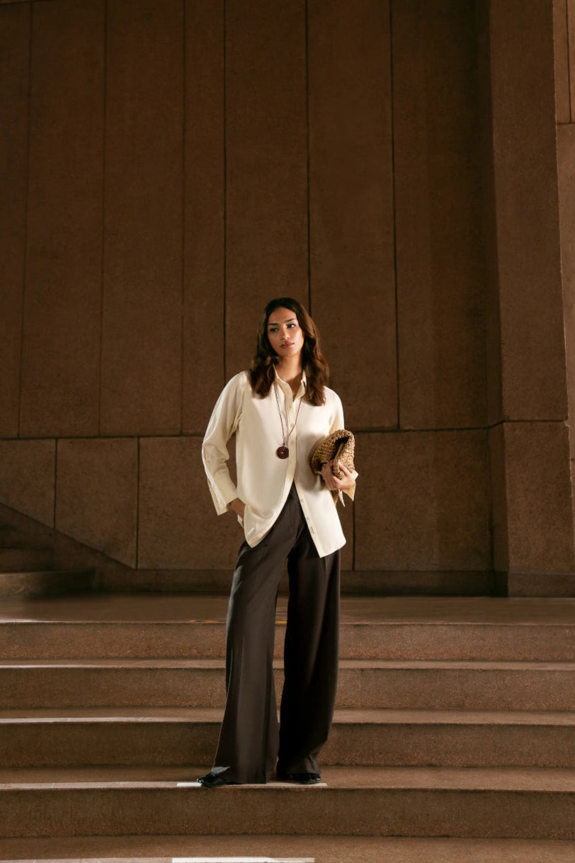 Woman standing on steps in front of a large stone wall
