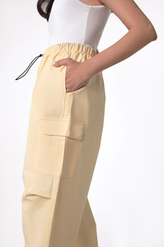 A person wearing yellow wide leg cargo pants with an elasticated waistband and side cargo pockets.