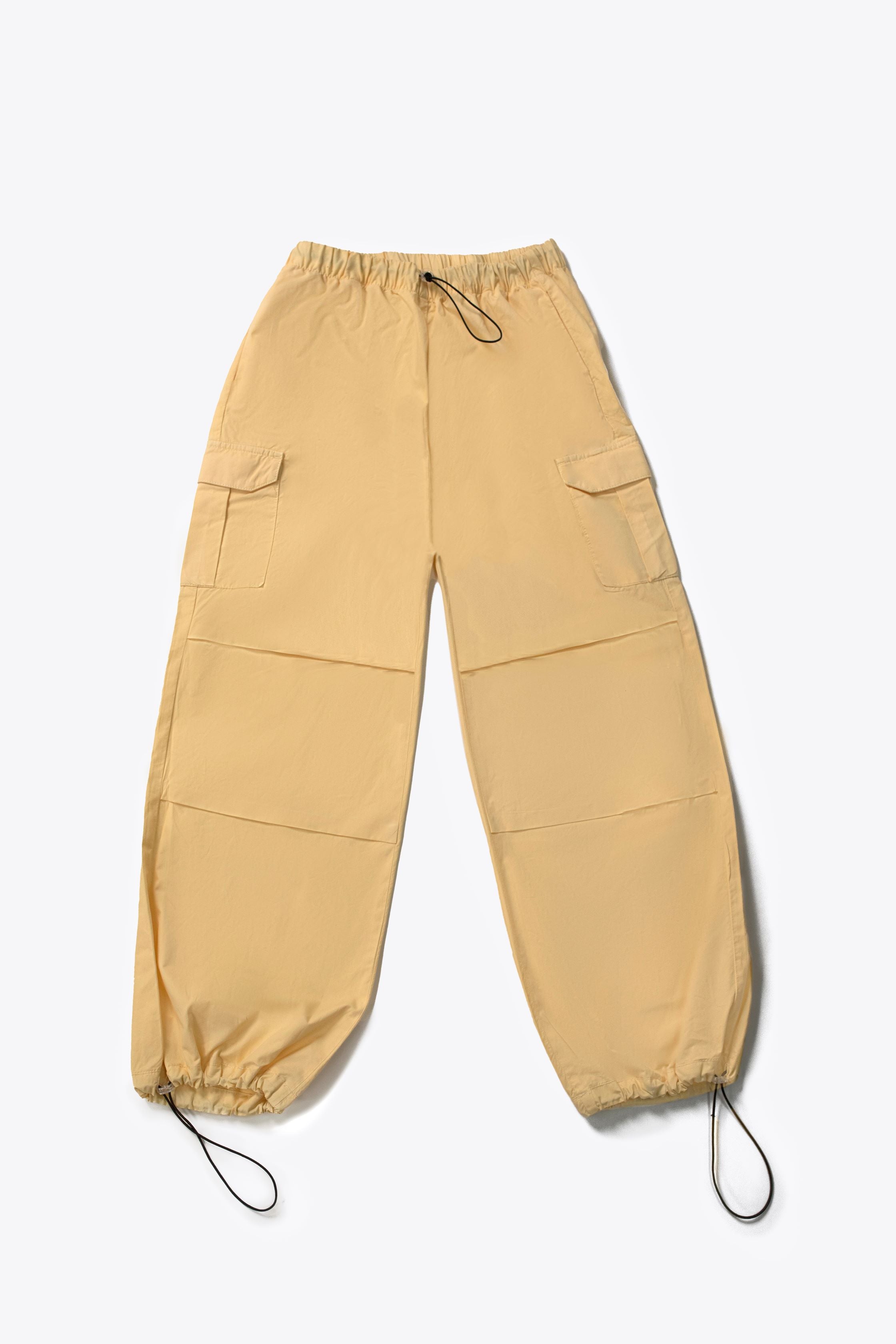 A person wearing yellow wide leg cargo pants with an elasticated waistband and side cargo pockets.