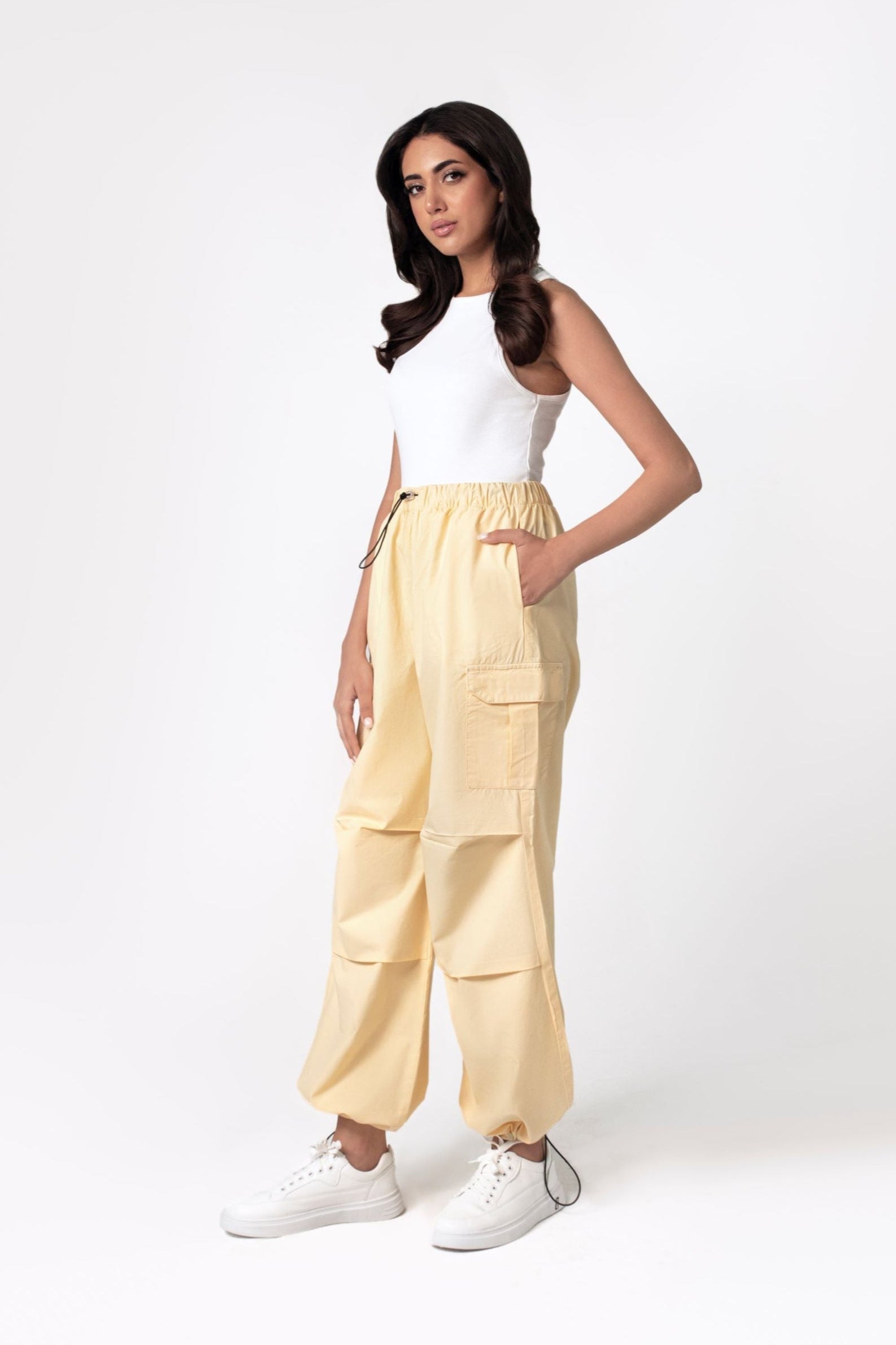 A person wearing yellow wide leg cargo pants with an elasticated waistband and side cargo pockets.
