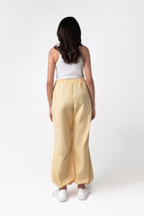 A person wearing yellow wide leg cargo pants with an elasticated waistband and side cargo pockets.