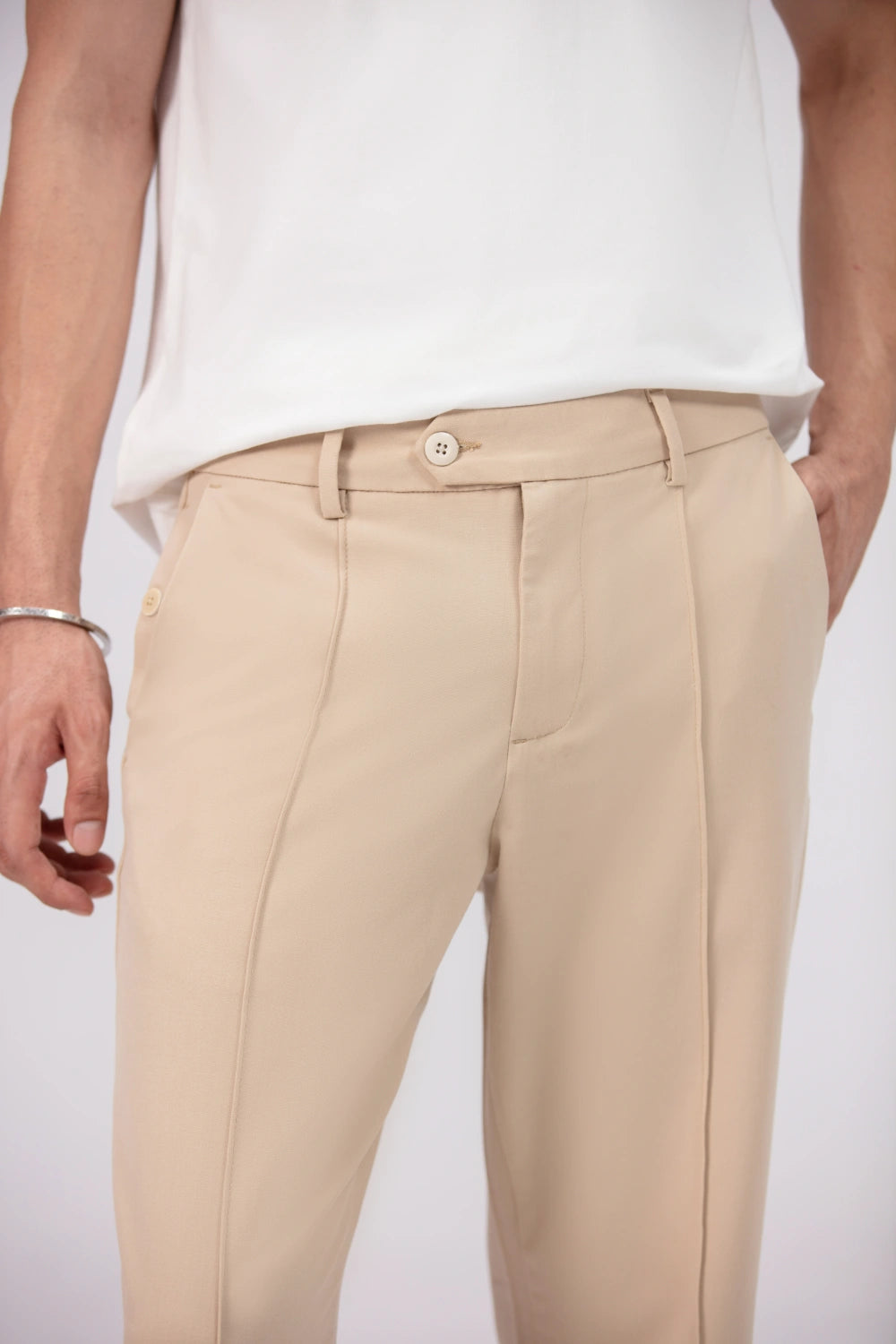 Man wearing a white t-shirt and beige pants on a white background