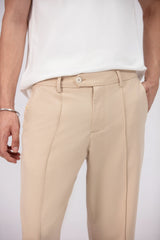 Man wearing a white t-shirt and beige pants on a white background